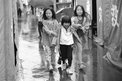 孩子们在雨中追逐打闹。